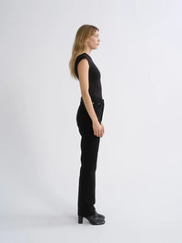 Side profile of the AGOLDE Agata Bodysuit in Black showing the cap sleeve and sculpted fit.