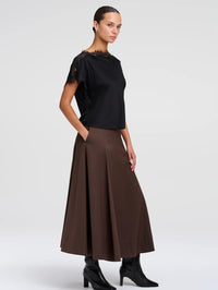 Side view of the A.L.C. Luna Top in Black styled with a brown midi skirt and black boots