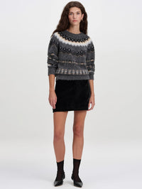 Front full-length view of the A.L.C. Petra Velvet Mini Skirt in Black styled with a grey sweater and black flats.