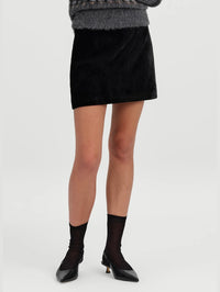 Front view from the waist down of the A.L.C. Petra Velvet Mini Skirt in Black with sheer socks and slingback heels.
