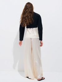 Back view of the Olivia Poplin Bolero in black by ALL THREE, styled with cream wide-leg trousers
