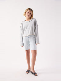 Full length view of the American Vintage Dantown Pullover in Melange Sky Blue styled with denim shorts