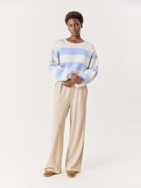 Full length view of the American Vintage Niby Sweater in Frosted Stripes with wide leg trousers