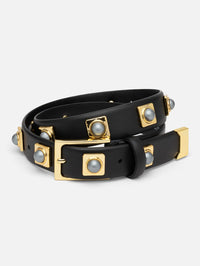 Coiled view of the Aureum No. 2 Belt in black leather with grey stone studs in gold-tone settings.