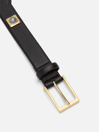 Buckle detail of the Aureum No. 2 Belt in black leather with a gold-tone buckle and grey stone stud.