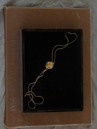 Flat lay of the BOLOLA NYC Jo Bolo in Gold with Citrine on a black velvet tray.
