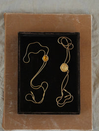 Flat lay of the BOLOLA NYC Lolita Bolo in Gold with Citrine on a black velvet tray.