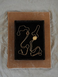 Flat lay of the BOLOLA NYC Lolita Bolo in Gold with Smokey Topaz on a velvet tray.