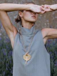 Model wearing the BOLOLA NYC Palmette Bolo in Gold with Smokey Topaz over a gray mock neck top.