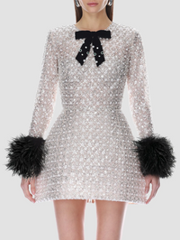 Front view of the silver sequin embellished mini dress with black bow and feather cuffs by Bronx Banco