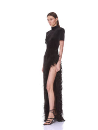 Side view of the Bronx and Banco black velvet maxi dress with ostrich feather trim and structured shoulders.