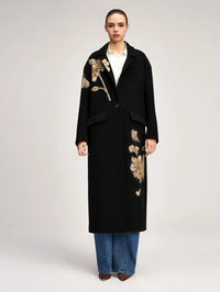 Front view of the Cinq à Sept Gilded Peony Lilienne Coat in Black/gold worn over a cream shirt and jeans