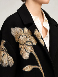 Close-up of the gold peony embroidery at the lapel of the Cinq à Sept Lilienne Coat in Black/gold