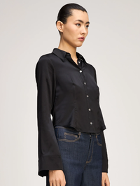 Side view of the Le Petit Petra Top in black by Cinq à Sept, styled with dark denim