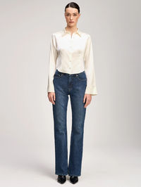 Front view of the Le Petit Petra Top in ivory by Cinq à Sept, styled with dark denim