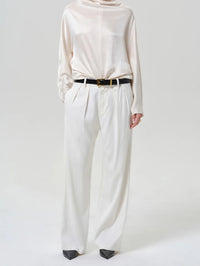 Front view of the Citizens of Humanity Ines Trouser in Winter White with a cream satin top and belt.