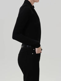 Side view of the Citizens of Humanity Sculptural Bodysuit in Black tucked into black jeans.