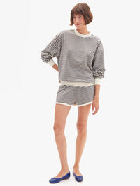 Front view of the Oversized Sweatshirt in black and cream stripes by Clare V., styled with matching shorts