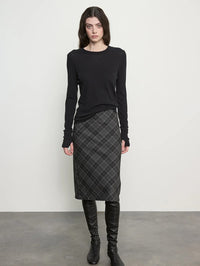 Front view of the Enza Costa Bias Minimal Skirt in Charcoal Plaid with a black knit top and tall boots.