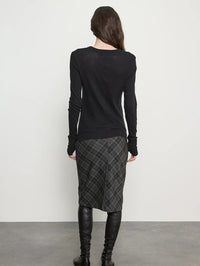 Back view of the Enza Costa Bias Minimal Skirt in Charcoal Plaid on a model in black boots.