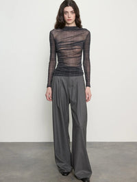 Front view of the ENZA COSTA Plaid Mesh Long Sleeve Twist Top in Shadow Plaid, styled with grey wide leg trousers.