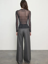 Back view of the ENZA COSTA Plaid Mesh Long Sleeve Twist Top in Shadow Plaid, sheer mesh through the back.