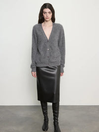 Full front view of the Enza Costa Mink Wash Cashmere Cardigan in Pewter buttoned over a black leather skirt.