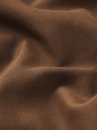Close-up of luxe fabric texture and draping on the Garden Dress in Moss Brown by FRAME