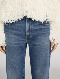 Close detail of the mid rise waistband and five pocket front on the FRAME The Hang jean in Lucky.