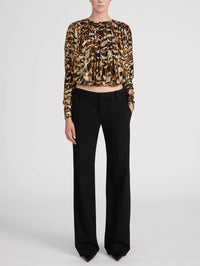 Full-length view of the FRAME Pleated Bubble Top in Abstract Leopard with black tailored trousers