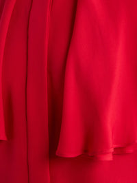 Detail of the Lipstick red silk and ruffle hem on the FRAME Wrap Cape Blouse.