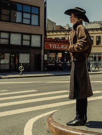 Street style shot of the Freda Salvador Nancie Western Boot in Navy Suede Combo under a long coat.