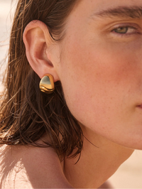 Close-up of Nelle Hoops in high polish gold by Jenny Bird, worn on model with brown hair