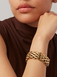 Close-up of the Penelope Bracelet in high polish gold by Jenny Bird, worn on wrist with brown tank top