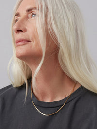 Model wearing the Jenny Bird Zeina Chain in gold, side profile with a grey tee.