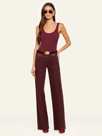 Front view of the Clayton High Rise Wide Leg Pant in Deep Sangria Coated by L'AGENCE, styled with a matching tank and gold…