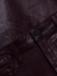 Close-up of the coated finish and button on the L'AGENCE Clayton pant in Deep Sangria Coated