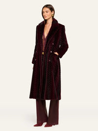 Three quarter view of the L'AGENCE Icelyn Long Coat in Burgundy/Dark Burgundy with hand in pocket