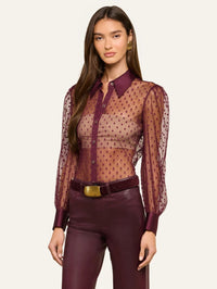 Three-quarter view of the L'AGENCE Sophie Swiss Dot Blouse in Deep Sangria tucked into burgundy pants