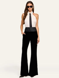 Full-length look of the L'AGENCE Wren Neck-Tie Top in White/Black with black velvet flare trousers