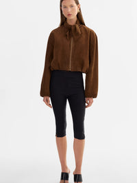 Full-length front view of the LAMARQUE Anita Suede Bomber Jacket in Brown worn with black cropped pants.