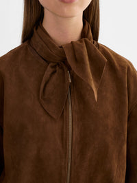 Close-up of the tie-neck scarf and gold zip on the LAMARQUE Anita Suede Bomber Jacket in Brown.