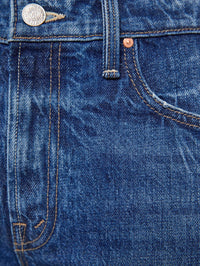Detail of the rigid mid-blue denim on the MOTHER Bookie Slit Twist Heel Fray Jean in Double Take