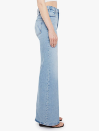 Side view of the Lil Hustler Roller Sneak Jean in I Confess by MOTHER, a light blue denim