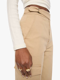 Close-up of the buckled pull-tab waistband and cargo pocket on MOTHER Prep Tune Up Cargo pants in Khaki.
