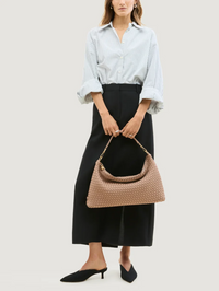 Front view of the Porto Medium Half-Moon Bag in Seychelle by Nag Hedieaux, styled with a striped shirt and black skirt