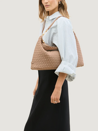 Side view of the Porto Medium Half-Moon Bag in Seychelles by NAGHEDI, styled with a striped shirt
