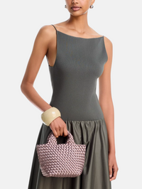 A model wearing a dark gray ribbed knit sleeveless top and matching skirt, holding a pink woven basket-style handbag against a light gray studio background.