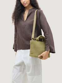 Front view of the St. Barths Small Tote in bottle green by Naghedi, styled with a charcoal linen top