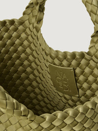 Close-up of woven lattice pattern and leather brand patch inside the St. Barths Small Tote in bottle green by Naghedi